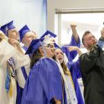 A group of graduating seniors take a selfie with teacher and head football coach Tony Haddenham while they wait for their graduation ceremony to begin on Saturday at Chimacum High School. (Steve Mullensky/for Peninsula Daily News)