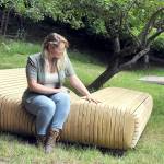 Rachel Storck, community engagement director for the Port Angeles Fine Arts Center, sits on the art installation Sky Gazer by Port Angeles artist Steve Belz, one of several new artworks in the Websters Woods Sculpture Park, the site of this weekends Summertide Solstice Arts Festival. (Keith Thorpe/Peninsula Daily News)