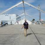 Steve Hargis, a board member of the Port Angeles Chamber of Commerce, directs the alignment of an events tent on Thursday that will cover a temporary roller skating rink in downtown Port Angeles. (KEITH THORPE/PENINSULA DAILY NEWS)