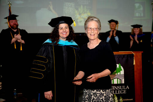 Peninsula College President Suzy Ames, left, presents Patty Morey an honorary Associate of Arts degree awarded to her late son, Mark Morey, at Saturdays afternoon commencement. Mark Morey studied journalism at the college in the 1990s and did not graduate. However, he went on to an award-winning career as a reporter at the Peninsula Daily News and the Yakima Herald-Republic. He died Jan. 29 of complications from colorectal cancer at the age of 46. (Jesse Major/Peninsula College).