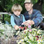 Noah Erickson, 2, snips a flower head with the help of his father, Chris Erickson of Port Angeles, while making a solstice crown headdress during the Summertide Solstice Art Festival on Saturday at the Port Angeles Fine Arts Center and adjoining Websters Woods Sculpture Park. The event served as a celebration of the coming of summer with a variety of food, music and outdoor activities. (Keith Thorpe/Peninsula Daily News)