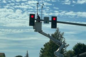 Staff with subcontractor GG Electric install radio and camera equipment at the North Fifth Avenue and Fir Street intersection to help traffic flow there and at seven signals across the City of Sequim. Work is anticipated to be completed by contractor Western Systems in early July, according to city staff. (Matthew Nash/Olympic Peninsula News Group)