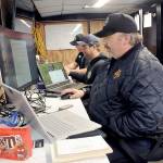 Fire managers, from front, Robert Thurston working with GIS, communications unit leader Carsen Smith and operations section chief Scott Coulson work at a command post for the Lake Sutherland Fire on Tuesday at Dry Creek School in Port Angeles. (Keith Thorpe/Peninsula Daily News)