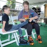 Devyn Roblan of Port Angeles makes adjustments to a rollerblade worn by her son, Miles Roblan, 7, on Fridays opening day of skating at the seasonal Olympic Skate Villege in downtown Port Angeles. (KEITH THORPE/PENINSULA DAILY NEWS)