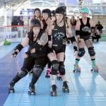 Port Scandalous Roller Derby team members Jamie Ginger Haire, front left, and Shauna LilyHammer Rogers-McClain, front right, bump into each other as the rest of their team follows in the pack during a demonstration skate on Thursday at the Olympic Skate Village in downtown Port Angeles. The demo was part of an opening celebration for the temporary roller skating rink, which opened for public skate sessions on Friday. (KEITH THORPE/PENINSULA DAILY NEWS)