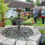 Dorothy Hoffman, left, and Anne Steurer, both of Port Townsend, examine a water feature in the backyard garden of Niki Kobes and Tom Riette in Carlsborg, one of five featured gardens during Saturdays 28th annual Petals & Pathways home garden tour. The event was hosted by the Master Gardener Foundation of Clallam County. (Keith Thorpe/Peninsula Daily News)