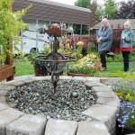 Dorothy Hoffman, left, and Anne Steurer, both of Port Townsend, examine a water feature in the backyard garden of Niki Kobes and Tom Riette in Carlsborg, one of five featured gardens during Saturdays 28th annual Petals & Pathways home garden tour. The event was hosted by the Master Gardener Foundation of Clallam County. (Keith Thorpe/Peninsula Daily News)