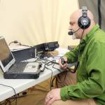 Radio operator Chris Icide of Joyce, who uses the call sign WY7W, talks to other radio stations while broadcasting from a tent on Saturday at the Clallam County Fairgrounds in Port Angeles as part of Field Day, an international competition where partcipants attempt to log as many contacts across the United States and Canada as possible in a 24-hour period. (KEITH THORPE/PENINSULA DAILY NEWS)