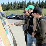 Olympic National Park visitors, from left, Nelson Nunez, Mateo Sancho and Albert Martinez, all from New York City, look at an information board at Hurricane Ridge after the area was reopened to the public on Tuesday. (Keith Thorpe/Peninsula Daily News)