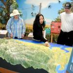 KEITH THORPE/PENINSULA DAILY NEWS
Dungeness River Nature Center visitors, from left, Chris McDonald of Port Angeles, Tram Pham of Huntington Beach, Calif., and Paul McDonald of Redmond examine a relief map display of the Dungeness River Watershed on Wednesday in Sequim. The center at Railroad Bridge Park offers a variety of displays and exhibits showcasing the nature and geography of the Dungeness River Valley.