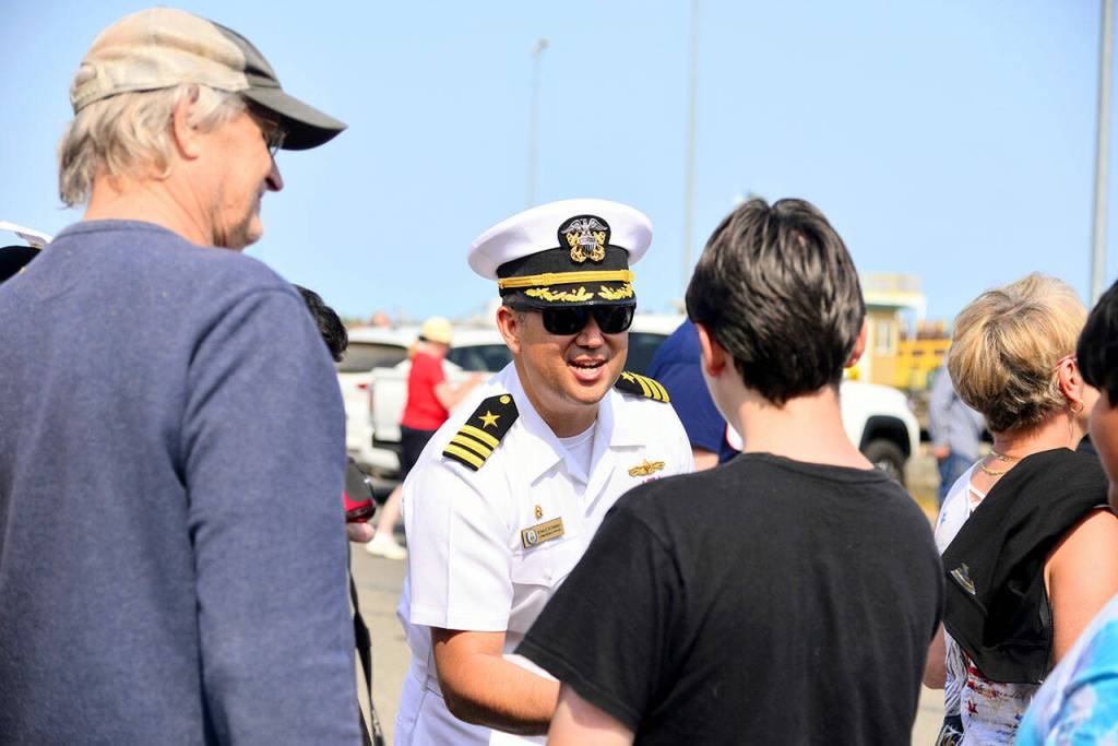 The USS Momsens commanding officer Commander Ryan Downing greets visitors waiting in line to tour the ship at the Port of Port Angeles on Tuesday. More than 1,000 people were lined up in the morning to see the U.S. Navy Destroyer. (Peter Segall/Peninsula Daily News)