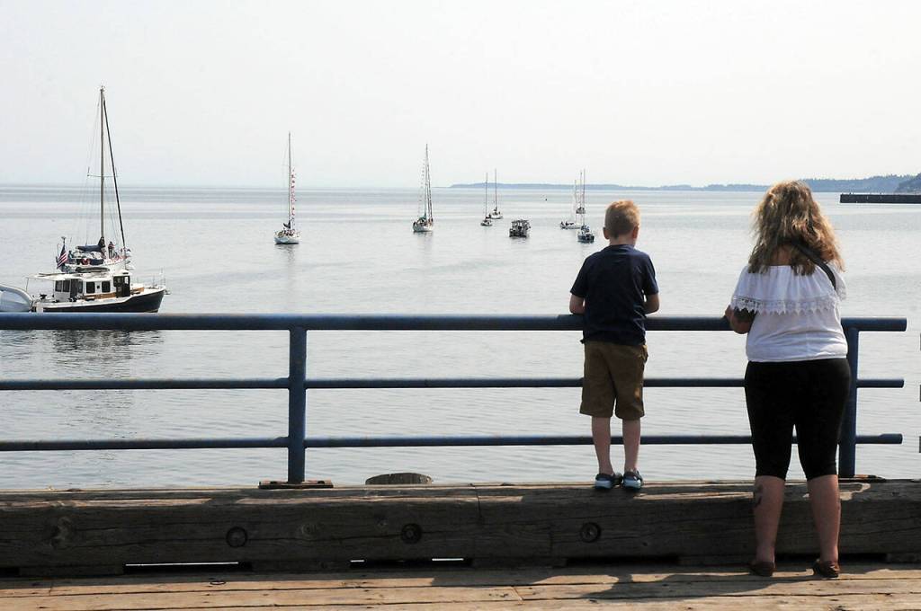 Colton Dryke, 7, and his mother, Sharon Dryke of Sequim, watch an Independence Day boat parade in Port Angeles Harbor as the procession sails past Port Angeles City Pier. (Keith Thorpe/Peninsula Daily News)
