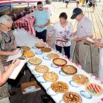 Apple pie contest judges, clockwise from left, Janet Lucas, John Brewer, Corey Delikat, Carol Johnson, Randy Johnson and Lt. Andrew Bergman judge entries prior to tasting during Independence Day festivities at Port Angeles City Pier. (Keith Thorpe/Peninsula Daily News)