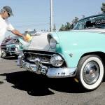 Mike Nikolaus of Chico polishes up his 1955 Ford Fairlane Sunliner during Fridays 26th annual Ruddell Cruise In car show at Ruddell Auto Mall in Port Angeles. The event drew hundreds of people to view dozens of antique and vintage automobiles for an evening of food, music and automotive nostalgia. (Keith Thorpe/Peninsula Daily News)