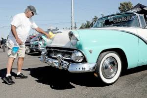 Mike Nikolaus of Chico polishes up his 1955 Ford Fairlane Sunliner during Fridays 26th annual Ruddell Cruise In car show at Ruddell Auto Mall in Port Angeles. The event drew hundreds of people to view dozens of antique and vintage automobiles for an evening of food, music and automotive nostalgia. (Keith Thorpe/Peninsula Daily News)