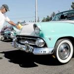 Mike Nikolaus of Chico polishes up his 1955 Ford Fairlane Sunliner during Fridays 26th annual Ruddell Cruise In car show at Ruddell Auto Mall in Port Angeles. The event drew hundreds of people to view dozens of antique and vintage automobiles for an evening of food, music and automotive nostalgia. (Keith Thorpe/Peninsula Daily News)