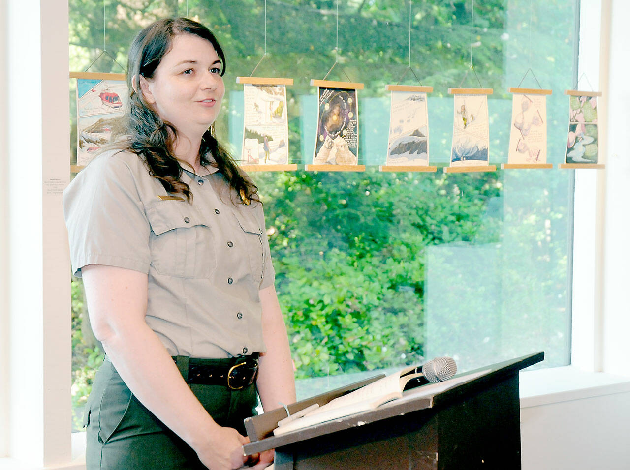 Olympic National Park Arist-in-Residence Program manager Eliza Goode provides an introduction to Terminus: A Glacier Memorial Project during an opening reception for a collection more than 40 art pieces themed around the effects of climate change on glaciers on Friay at the Port Angeles Fine Arts Center. (KEITH THORPE/PENINSULA DAILY NEWS)