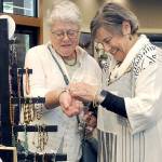 Carol Pearson of Sequim-based Lizzie Betz Jewelry assists Maureen Kennedy of Port Angeles with a bracelet during Saturdays Rain Shadow Artisans Fair at the Dungeness River Nature Center in Sequim. The event brought together more than a dozen local crafters with the opportunity to market their wares. (Keith Thorpe/Peninsula Daily News)