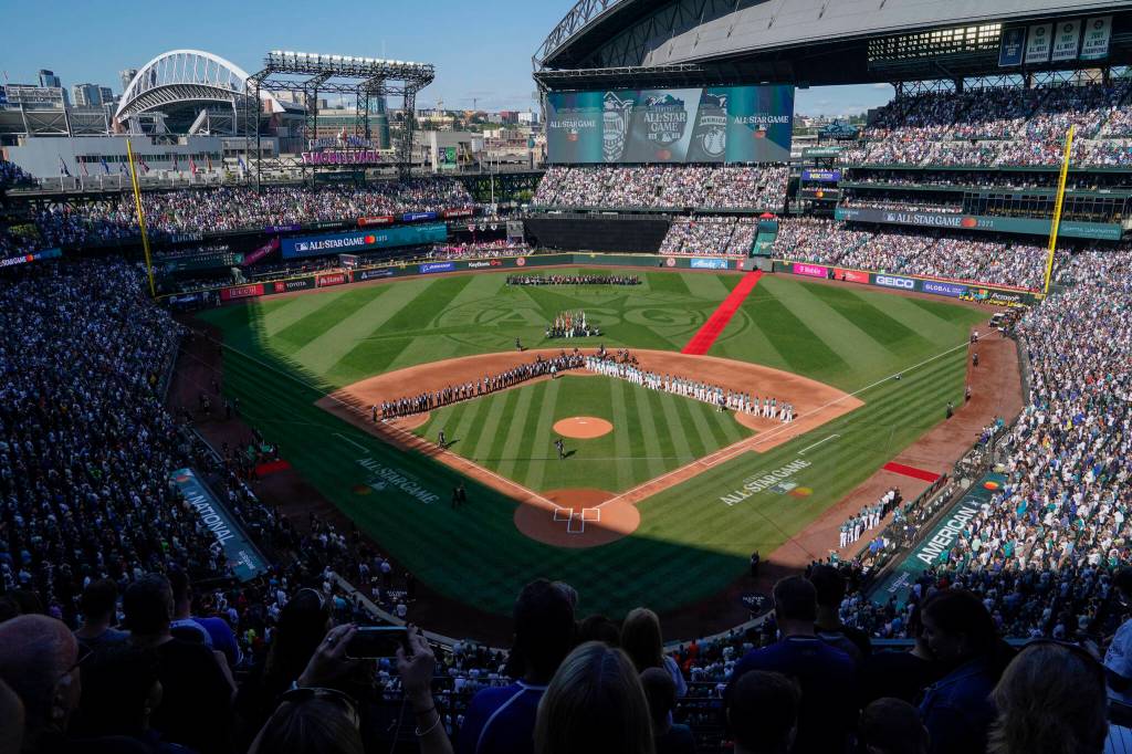 The All-Star Game logo is seen on the field at T-Mobile Park during the national anthem before the baseball game in Seattle, Tuesday, July 11, 2023. (AP Photo/Ted S. Warren)