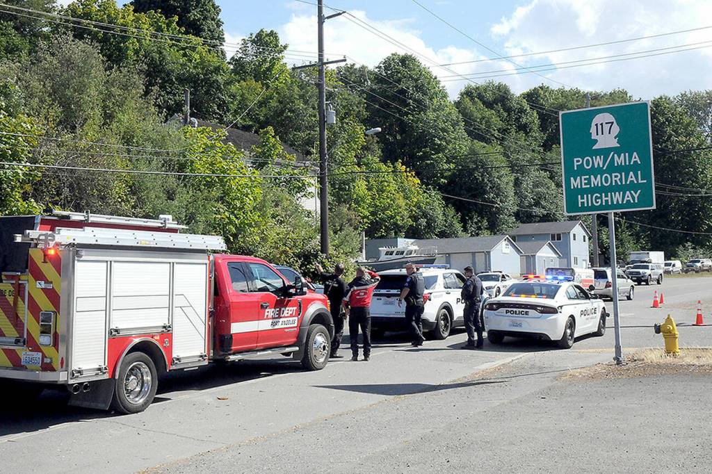 Port Angeles police and firefighters examine a utility pole and a downed powerline along the Tumwater Truck Route at Third Street that disrupted traffic and caused power outages on Wednesday afternoon. (Keith Thorpe/Peninsula Daily News)