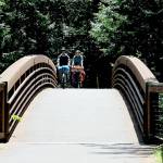 KEITH THORPE/PENINSULA DAILY NEWS
Tom Rooney of Seattle, left, and Marie Cazanave of Montreal, Quebec ride their bicycles over a 201-foot long footbridge spanning a small creek on Thursday at Sequim Bay State Park east of Sequim. The pair were on a bicycle camping excursion along the Olympic Discovery Trail.