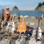 Quileute Tribal member Dana Williams prepares baked salmon in the old traditional way on Saturday while the Quillayute River flows to the sea. This tradition is included in the Quileute Days celebration held each year at LaPush. (Lonnie Archibald/for Peninsula Daily News)