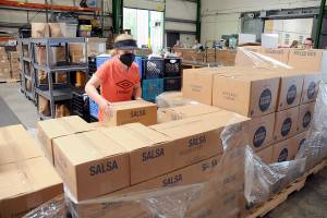Ellie Hales, 11, of Port Angeles, a member of the Church of Jesus Christ of Latter Day Saints, helps sort boxes of food that were donated to the Port Angeles Food Bank by the Mormon Churchs food operations in Utah. A total of 24 pallets of food and personal items weighing about 20 tons were to be divided up by local church members for later distribution to food banks in Forks, Sequim and Port Townsend, as well as Port Angeles. (Keith Thorpe/Peninsula Daily News)