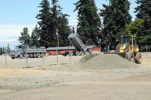 A tandem dump truck delivers sub-surface material on Wednesday at the site of the future Monroe Playfield at Roosevelt School in Port Angeles. (Keith Thorpe/Peninsula Daily News)