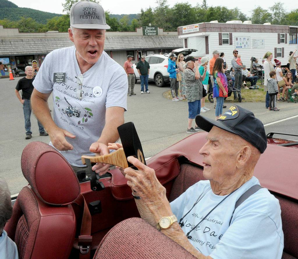Lifelong Joyce resident and unofficial mayor John Singhose, 95, right, receives a key to the city fashioned from a hand ax from Joyce Daze Wild Blackberry Festival chairman John Kent during Saturdays grand parade. (Keith Thorpe/Peninsula Daily News)
