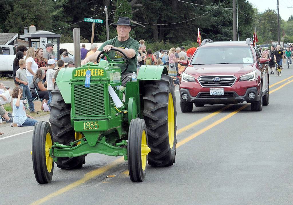 Jef Boyd drives his familys 1935 John Deere tractor in the Joyce Daze Grand Parade on Saturday. (Keith Thorpe/Peninsula Daily News)