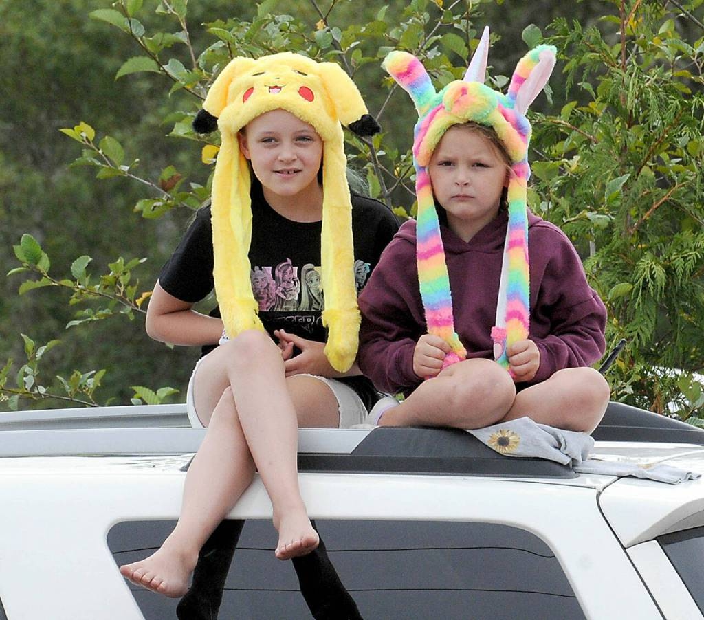 Sisters Addi Helgeson, 9, left, and Kammi Helgeson, 7, both of Port Angeles, watch the Joyce Daze grand parade from the top of a van along the parade route on Saturday. (Keith Thorpe/Peninsula Daily News)