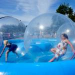 Emma Miller, 11, right, and best friend Lorelei Sanders, 11, both from Sequim, bounce around in the floating bubbles while at the 2023 Jefferson County Fair on Friday. (Steve Mullensky/for Peninsula Daily News)