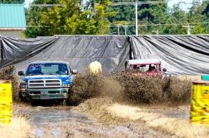 Richard Bauden of Port Angeles, left, in a 2000 Dodge, gets edged out for second place by Poulsbos Carl Jantz, driving a 1942 Willys Jeep during the Jefferson County Fair in Port Townsend on Sunday. Jantz won the 2014 Alaska Offroad Warriors reality competition off-road race with this vehicle, which covered 1,100 miles from south to north to the Arctic Ocean. (Steve Mullensky/for Peninsula Daily News)