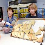Jammers Cindy Kelly, left, and Shelly Romero prepare freshly baked scones for distribution on Wednesday in the scone kitchen at the Clallam County Fairgrounds. (Keith Thorpe/Peninsula Daily News)