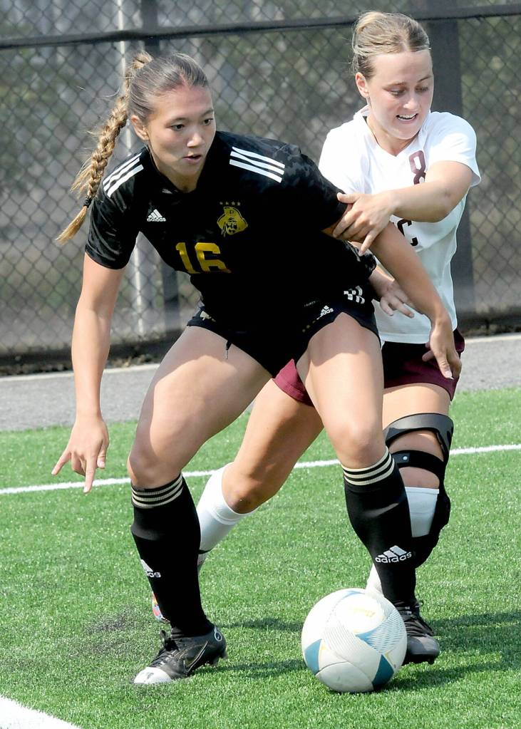 Peninsulas Shawna Larson, left, keeps the ball inbounds in the corner as North Idahos Ansley Kerley defends on Saturday in Port Angeles. (Keith Thorpe/Peninsula Daily News)