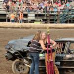 Amber Charles receives a trophy from derby organizer Julia Little for winning the powder puff division of the Clallam County Fair demolition derby. (Dave Logan/for Peninsula Daily News)