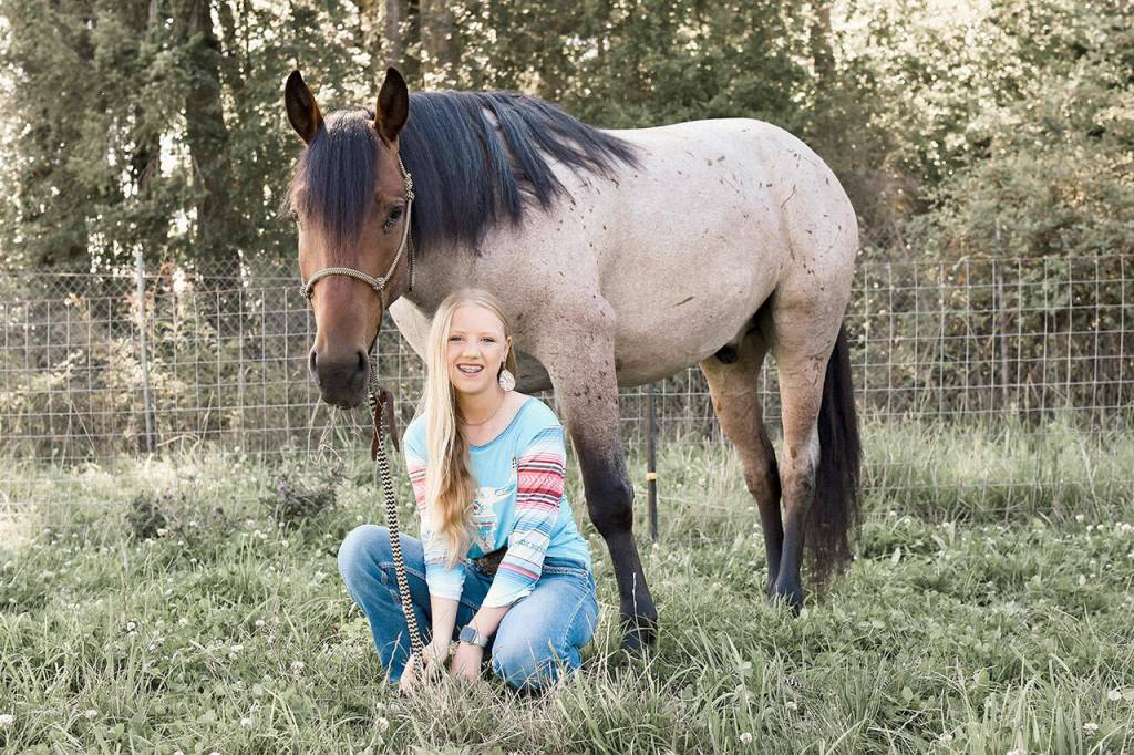 Asha Swanberg (with Steel) and her sister Libby adopted wild, never before handled BLM mustangs from the South Steens herd in Oregon to take part in the MYWY TIP challenge Mustang Makeover event. Their intense 120-day training program ended when the horses were sold at the MYWY auction at the Washington Horse Park in Cle Elum Aug.13. (Photo by Anna Swanberg)