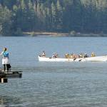 A canoe containing visitors to Nature Bridge at Lake Crescent in Olympic National Park makes its way past the dock at Lake Crescent Lodge on Thursday. The canoe was one of a pair plying the waters of the lake, mixing with a variety of other paddleboards and kayaks in the Barnes Point area. (Keith Thorpe/Peninsula Daily News)