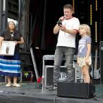 Jeremiah Green, a founding member of the indie rock band Modest Mouse, is remembered at THING as his brother, Adam Green, and his son, Wilder, 7, read tributes from band members during a dedication of the Littlefield Green to Jeremiah Green at McCurdy Pavilion in Fort Worden. Mari Hulbutta, from the Muskogee Tribe in Oklahoma, presented an Eagle feather to Wilder to give him strength and help guide him on his way in life. Jeremiah Green died of cancer in December. He had lived in Port Townsend for 20 years.(Steve Mullensky/for Peninsula Daily News)