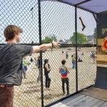 Steve Mullensky/for Peninsula Daily News 

Dayton Brown, from Sammamish, aims for the bull’s eye in the PNWAXE cage during THING music and arts festival on the Parade grounds of Fort Worden State Park on Friday. THING continues today and Sunday.