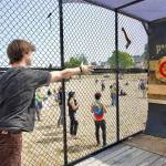 Dayton Brown, from Sammamish, aims for the bulls eye in the PNWAXE cage during THING music and arts festival on the Parade grounds of Fort Worden State Park on Friday. THING continues today and Sunday. (Steve Mullensky/for Peninsula Daily News)