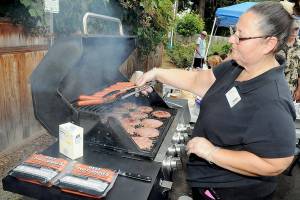 KEITH THORPE/PENINSULA DAILY NEWS
Diana Bossell, dietary manager with Peninsula Behavioral Health, grills hot dogs and hamburgers during a barbecue picnic and resource fair in honor of Overdose Awareness Day, observed on Thursday at Peninsula Behavioral Health’s Horizon Center in Port Angeles. The event, co-hosted by the North Olympic Healthcare Network, was designed to raise awareness of substance abuse and the effects of overdoses on victims and their families. Overdose Awareness Day included a rally at the Clallam County Courthouse and a remembrance march to Port Angeles City Pier.