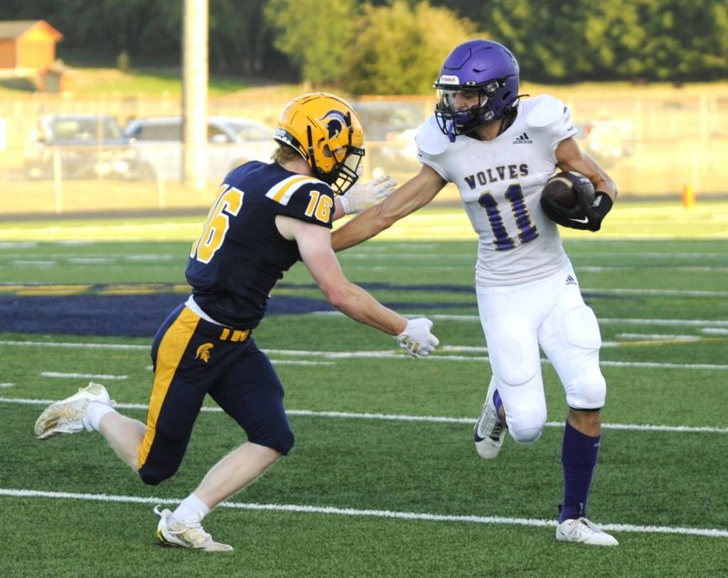 Sequims Alexander Kessler (11) fights for yardage against Forks Gunner Rogers (16) on Friday night in Forks. (Michael Dashiell/Olympic Peninsula News Group)