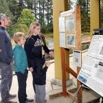 Members of the Bagley family of Forsyth, Ill., from left, parents Jessica and Cameron Bagley, and children Cody, 10, Addie, 12, and C.J., 7, look at an information kiosk on the Olympic National Park wildfires on Tuesday in front of the park visitor center in Port Angeles. (Keith Thorpe/Peninsula Daily News)