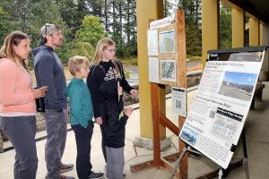 Members of the Bagley family of Forsyth, Ill., from left, parents Jessica and Cameron Bagley, and children Cody, 10, Addie, 12, and C.J., 7, look at an information kiosk on the Olympic National Park wildfires on Tuesday in front of the park visitor center in Port Angeles. (Keith Thorpe/Peninsula Daily News)