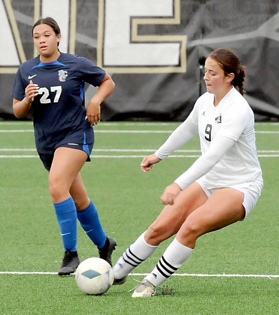 KEITH THORPE/PENINSULA DAILY NEWS Peninsulas Lauren La Fountain, right, addresses the ball as Bellevues Emalee Flemming tries to keep up on Saturday at Wally Sigmar Field.
