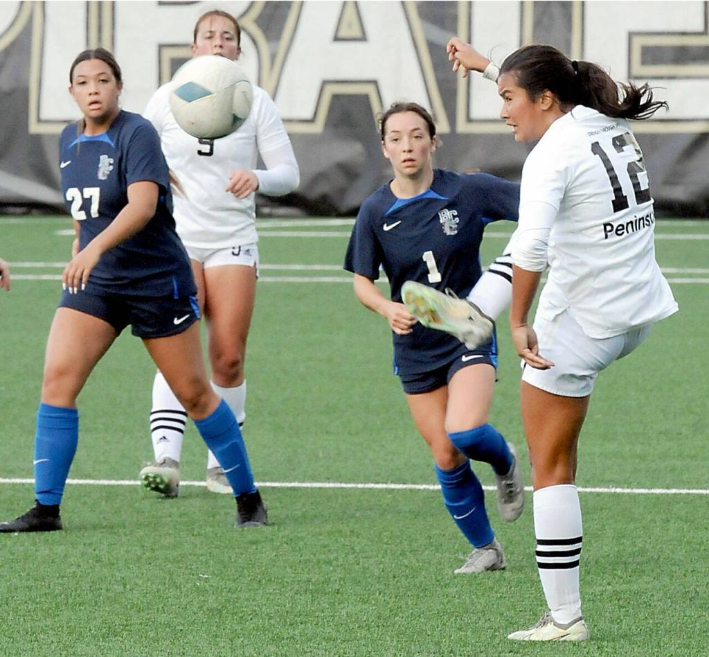 KEITH THORPE/PENINSULA DAILY NEWS Peninsulas Keilee Silva, right, sends the ball downfield as Bellevues Emalee Flemming, left, Peninsulas Lauren La Fountain and Bellevues Macie Masterson look on during Saturdays match in Port Angeles.