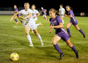 With teammate Sasha Yada, left, racing into Spartan territory, Sequim's Taryn Johnson looks to advance the ball against Bainbridge on Tuesday. Johnson scored both goals in the 2-1 win, including the game-winner in double overtime. (Michael Dashiell/Olympic Peninsula News Group)