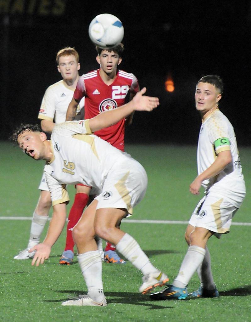 Peninsulas Konrad Muller, front, lands off balance from a header as teammate Pipvan der Ende, rear left, Skagit Valleys Iker Trevino and Peninsulas Maurin Frehner, right, look on during Wednesdays match at Peninsula College. (Keith Thorpe/Peninsula Daily News)