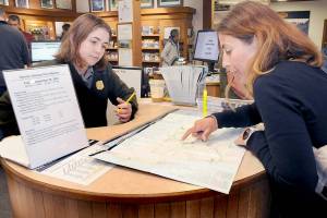 KEITH THORPE/PENINSULA DAILY NEWS
Olympic National Park visitor Sandra Schmidt of Leipzig, Germany, right, looks over a map of the park with interpretive ranger Emily Ryan on Friday at the park's visitor center in Port Angeles.